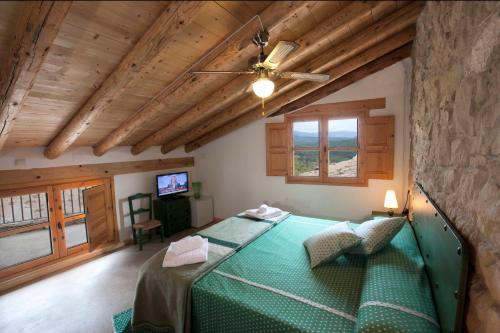 Un dormitorio con una cama verde en una habitación con techos de madera. en Solano de Moran, en Murillo de Gállego