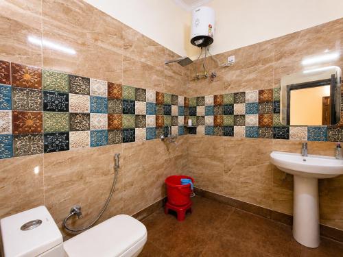 a bathroom with a toilet and a sink at Bhagirathi Residency in Rishīkesh
