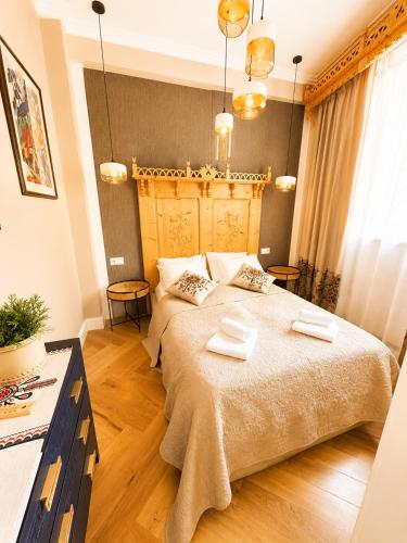 a bedroom with a large bed with two towels on it at My Mountain View - 50 m od Krupówek in Zakopane