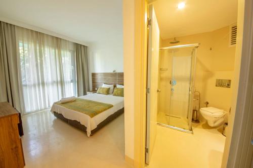 a bedroom with a bed and a shower and a toilet at La Moda Beach Hotel in Kaş