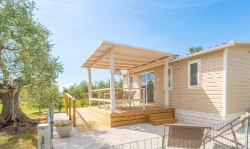 a tiny house with a porch and a deck at Agricamping L'Ibisco in Riotorto
