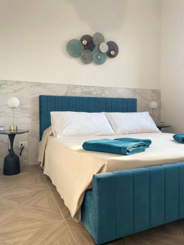 a bedroom with a bed with a blue headboard at Essenza di Mare Luxury B&B in Torre dell'Orso