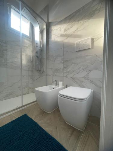 a white bathroom with a toilet and a shower at Essenza di Mare Luxury B&B in Torre dell'Orso