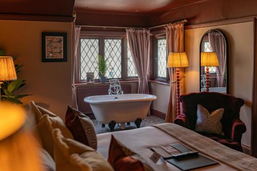 a bathroom with a tub and a couch and a bed at The Mayflower in Lymington