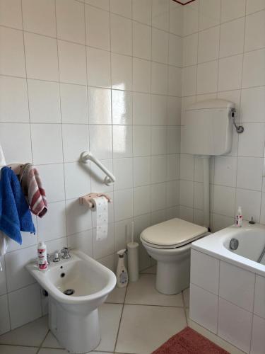 a white bathroom with a toilet and a sink at Comfort Home in Capoterra