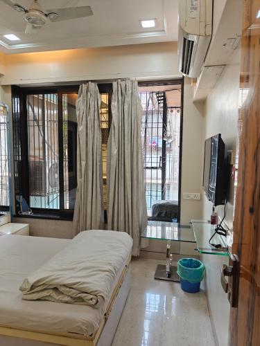 a hospital room with a bed and a window at Meenaji's home in Mumbai