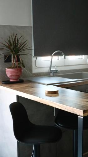 a kitchen with a wooden counter with a black chair at Mountain Aura - Stylish Escape in Kamarítsa