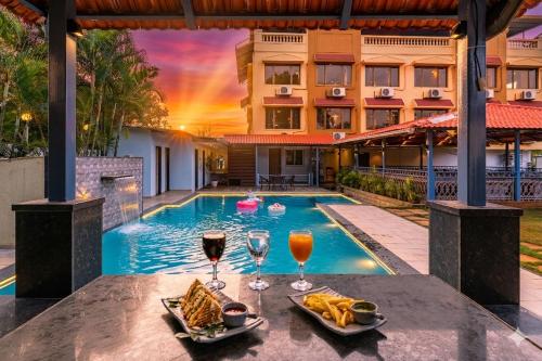 a hotel with a pool with glasses of wine at Mountview Resort in Lonavala