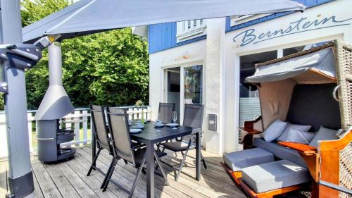 a table and chairs under an umbrella on a deck at Strandhaus Bernstein in Breege in Breege