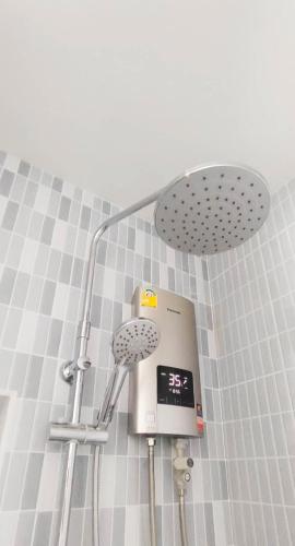 a shower with a clock in a bathroom at DD Villa in Pathiu