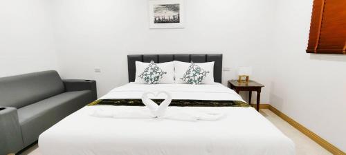 a bedroom with a bed with a white ribbon on it at DD Villa in Pathiu