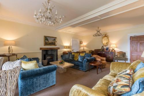ein Wohnzimmer mit blauen Möbeln und einem Kronleuchter in der Unterkunft Altskeith Country House in Aberfoyle
