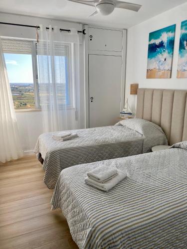 a bedroom with two beds with towels on them at Sea View urban apartment in Faro