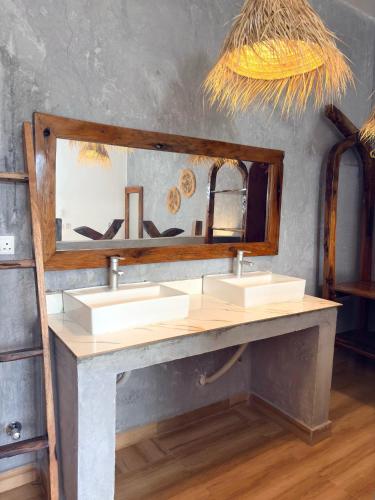 a bathroom with two sinks and a large mirror at NoyaAfrika Kendwa Boutique in Kendwa