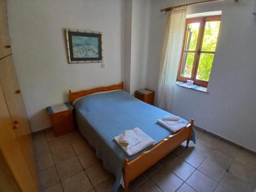 ein Schlafzimmer mit einem Bett, auf dem zwei Handtücher liegen in der Unterkunft Spanos House in Goudhi