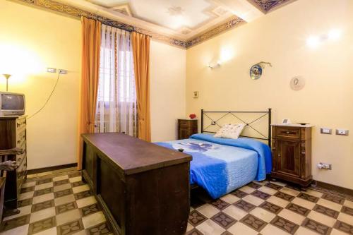 Schlafzimmer mit einem Bett mit blauer Bettwäsche und einem TV in der Unterkunft HouSmart Palestro 5 in Bologna