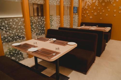 a dining room with two tables and a table and chairs at Hotel Siddharth Grand in Varanasi