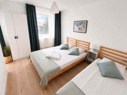 a bedroom with two beds and a window at B&B Fajne Miejsce in Łeba