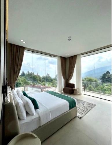 a bedroom with a large bed and a large window at Divan Hills in Campaka