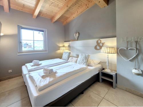 a bedroom with a large white bed with a heart on the wall at Peak View Penthouse Kaprun in Kaprun