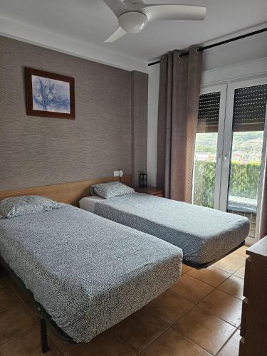 a bedroom with two beds and a window at 2 Duplex Las Terrazas Cubes in Vélez de Benaudalla