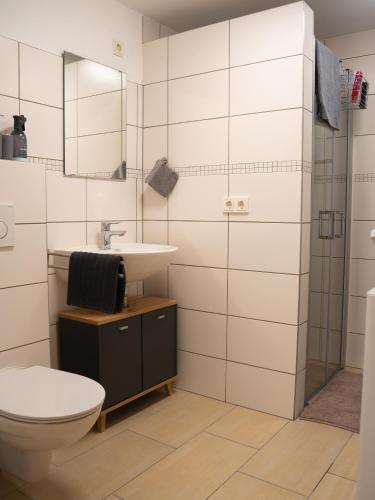 a bathroom with a toilet and a sink and a shower at Ferienwohnung Carl in Weikersheim