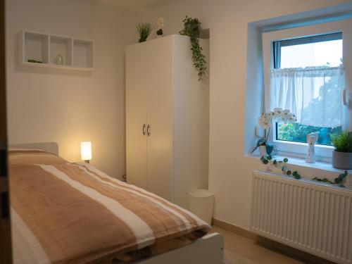 a bedroom with a bed and a window at Ferienwohnung Carl in Weikersheim