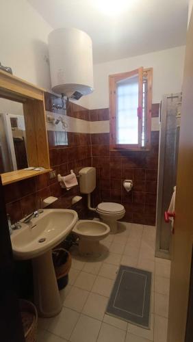 a bathroom with a sink and a toilet and a window at Pomposa 41 in Lido di Pomposa