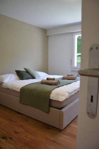 a bedroom with a large white bed with a window at TheCozyHideaway in Lungern
