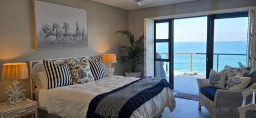 a bedroom with a bed and a view of the ocean at Benka Beach, Sheffield, KwaZulu Natal in Sheffield Beach