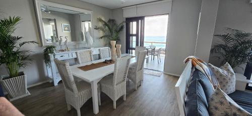 a dining room with a white table and chairs at Benka Beach, Sheffield, KwaZulu Natal in Sheffield Beach