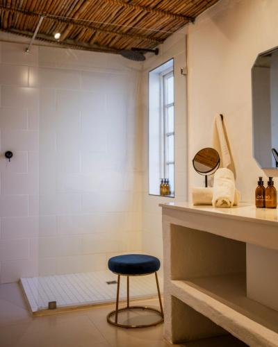 a bathroom with a stool in front of a shower at Stanford Valley Country Lodge in Stanford
