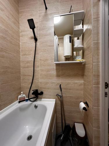 a bathroom with a bath tub and a mirror at 1 комн.квартира in Balqash