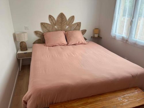 a bed with pink pillows in a bedroom at L'escale Cognaçaise in Cognac