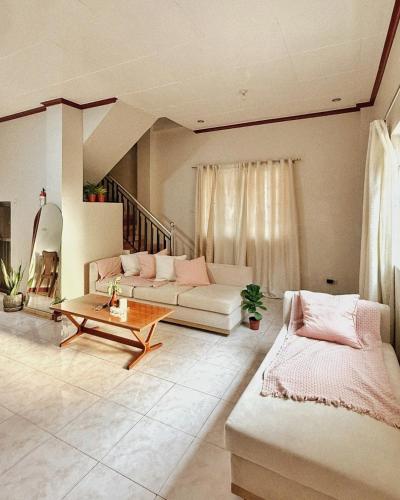 a living room with a couch and a table at Casa Clara La Union in Dalumpinas Oeste