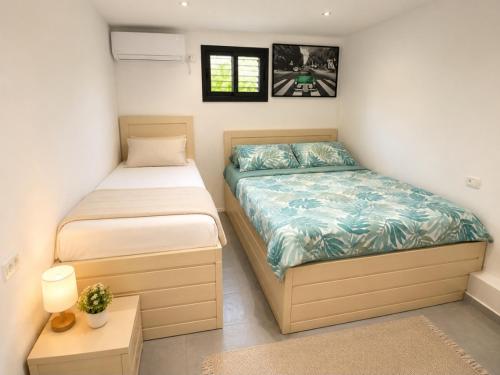 a bedroom with two beds and a night stand at נופש חלומי בכנרת in Tiberias