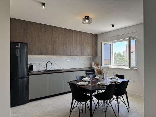 a kitchen with a table with chairs and a refrigerator at Apartment Terra Verde in Kastel Stari