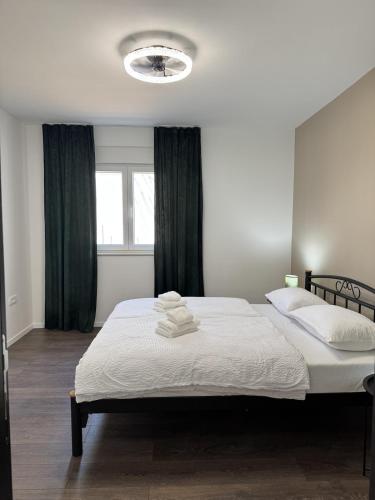 a bedroom with a large white bed and a window at Apartment Terra Verde in Kastel Stari