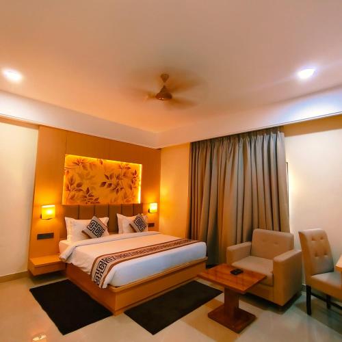 a hotel room with a bed and a chair at Hotel Siddharth Grand in Varanasi