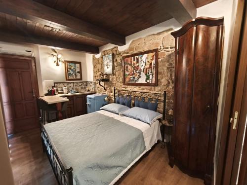 a bedroom with a bed and a stone wall at La Casa delle Rondini in Baunei