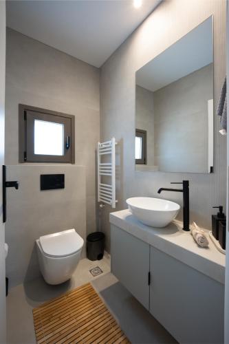 a bathroom with a toilet and a sink and a mirror at Kaerati Athens in Vari