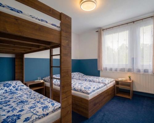 two bunk beds in a room with blue walls at Chata Pod Hájkem in Vrchlabí