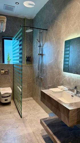 a bathroom with a sink and a shower and a toilet at فندق ايلانا بلس in Farasan