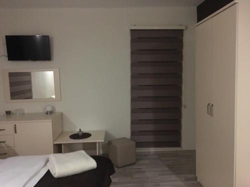 a bedroom with a bed and a desk and a door at Hotel Restoran EPI in Valandovo