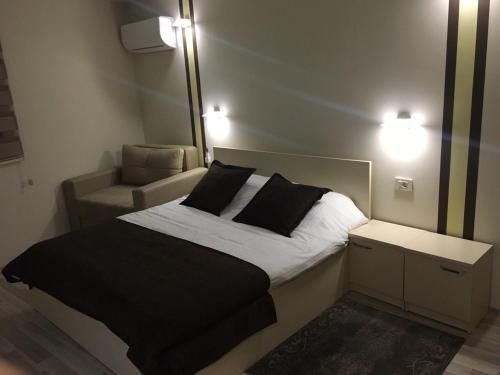 una camera da letto con un letto con specchio e una sedia di Hotel Restoran EPI a Valandovo