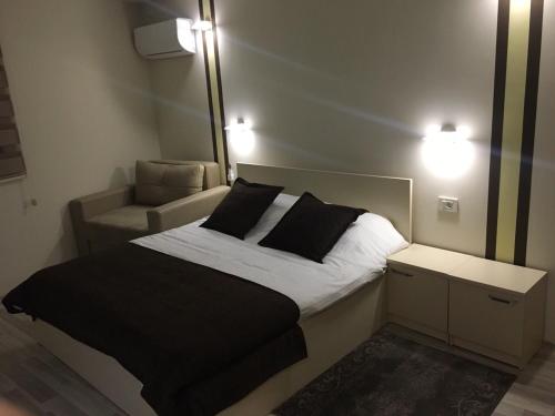 a bedroom with a bed with a mirror and a chair at Hotel Restoran EPI in Valandovo