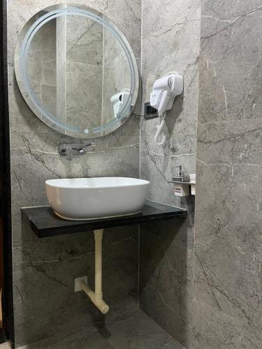 a bathroom with a sink and a mirror at Ace Inn Hotel in Nagpur