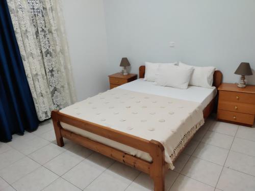 a bed in a room with two night stands and two lamps at Panorama Apartment 1 in Moúdhros