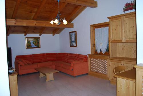 uma sala de estar com um sofá vermelho e uma mesa em Bait da Befin em Livigno