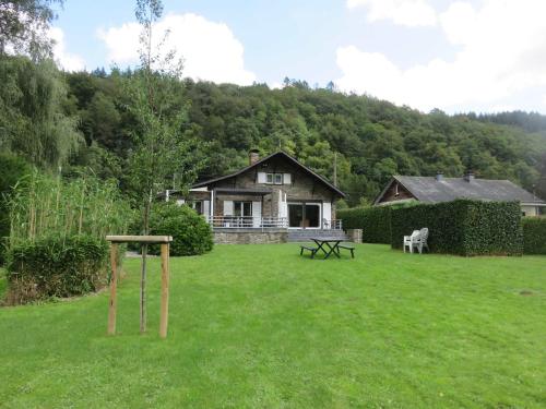 a yard with a house and a table in the grass at La Semois Et Moi in Rochehaut